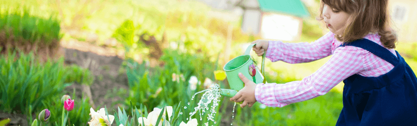girl watering plants in garden